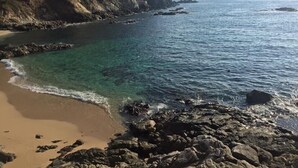 A coastal beach with clear water, rocky shoreline, and a cliff. - Casa El Delfin, 2nd Floor-Apt. 1 -  Estacahuite (Estacahuite)