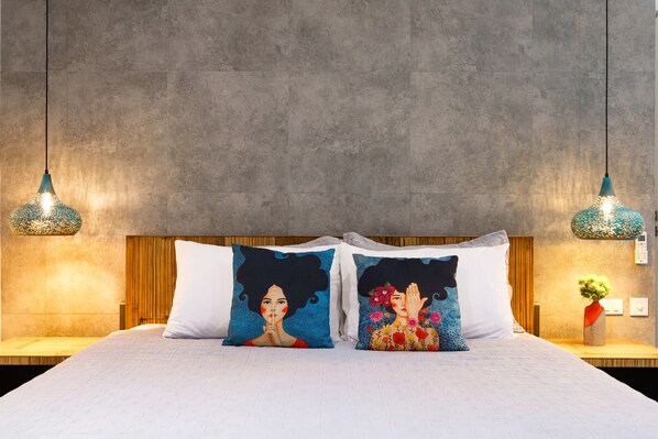 A bed with two decorative pillows, a wooden headboard, and two hanging light fixtures. - Villa Casa Bella - Luxury, Private Pool Villa  (Koh Samui)