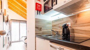 A modern kitchen with a built-in stove, sink, and coffee maker. - Estúdio-suite com Varanda a 2 Minutos a pé da Praia de Peniche (Peniche)