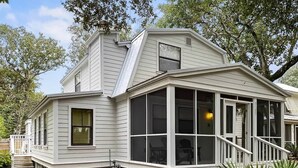 A two-story house with a bay window, a covered porch, and a staircase leading to the upper level.