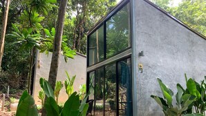 Un edificio moderno con amplios ventanales, rodeado de exuberante vegetación.