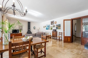 A spacious living area with a dining table, chairs, a sofa, and a fireplace.