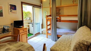 A cozy room with a bunk bed, a desk with a computer, a chair, and a small table.