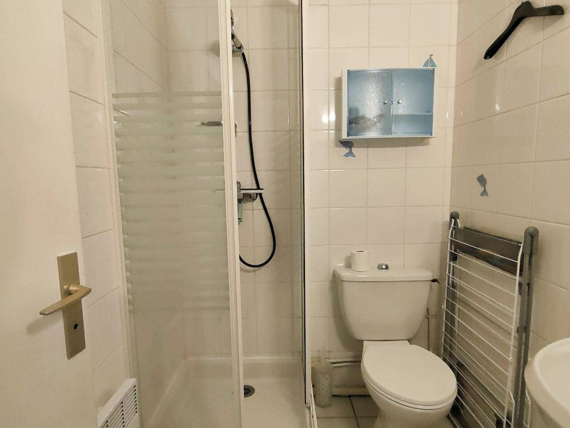 A small bathroom with a glass-enclosed shower, a toilet, and a sink.