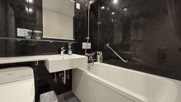 Un baño moderno con un lavamanos, espejo y bañera blancos.