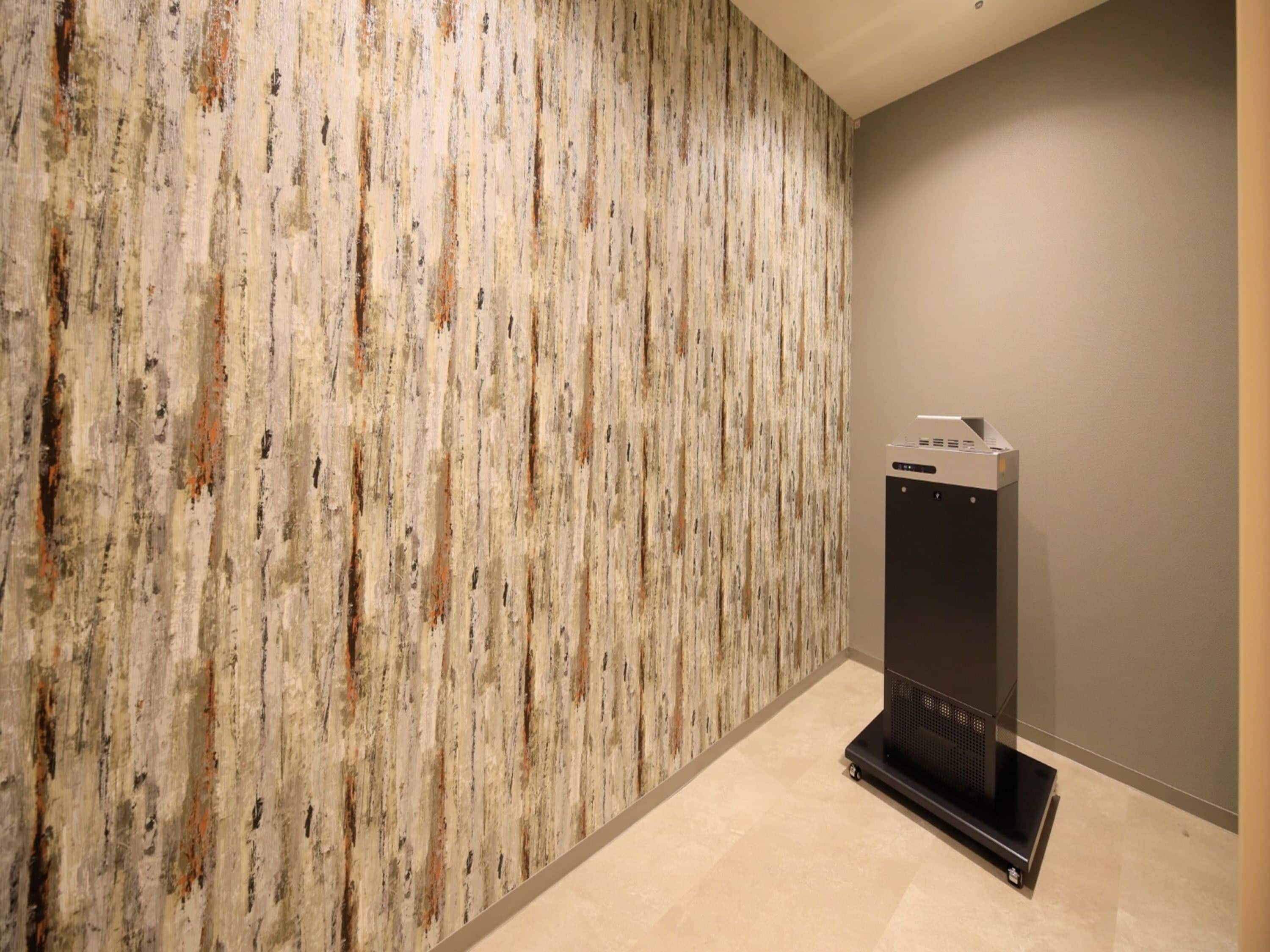 A hallway with a textured wall and a stationary elevator.