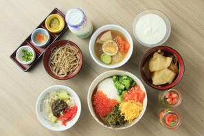 Variedad de platos japoneses, incluyendo fideos, sopa y sashimi.