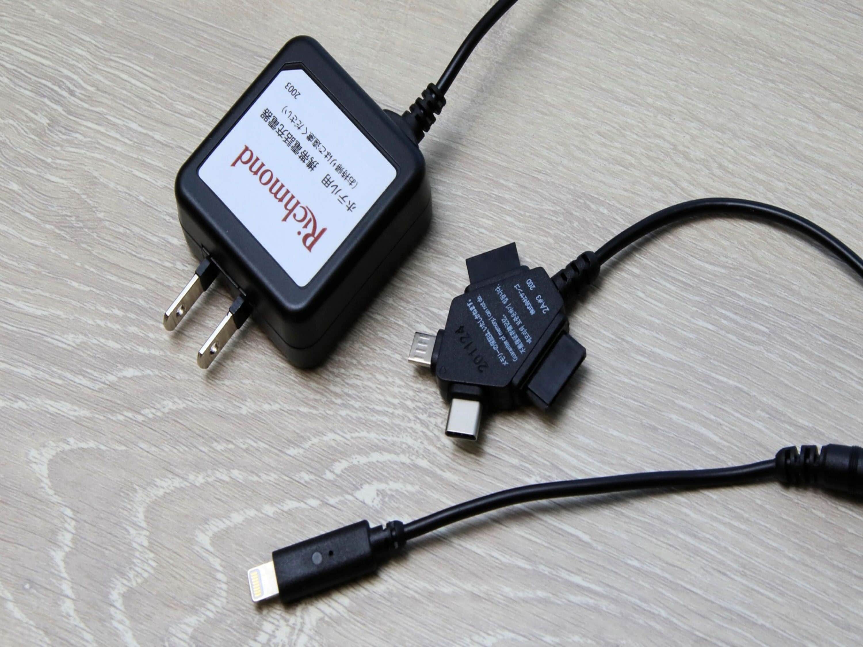 A power adapter with a label and a USB cable.