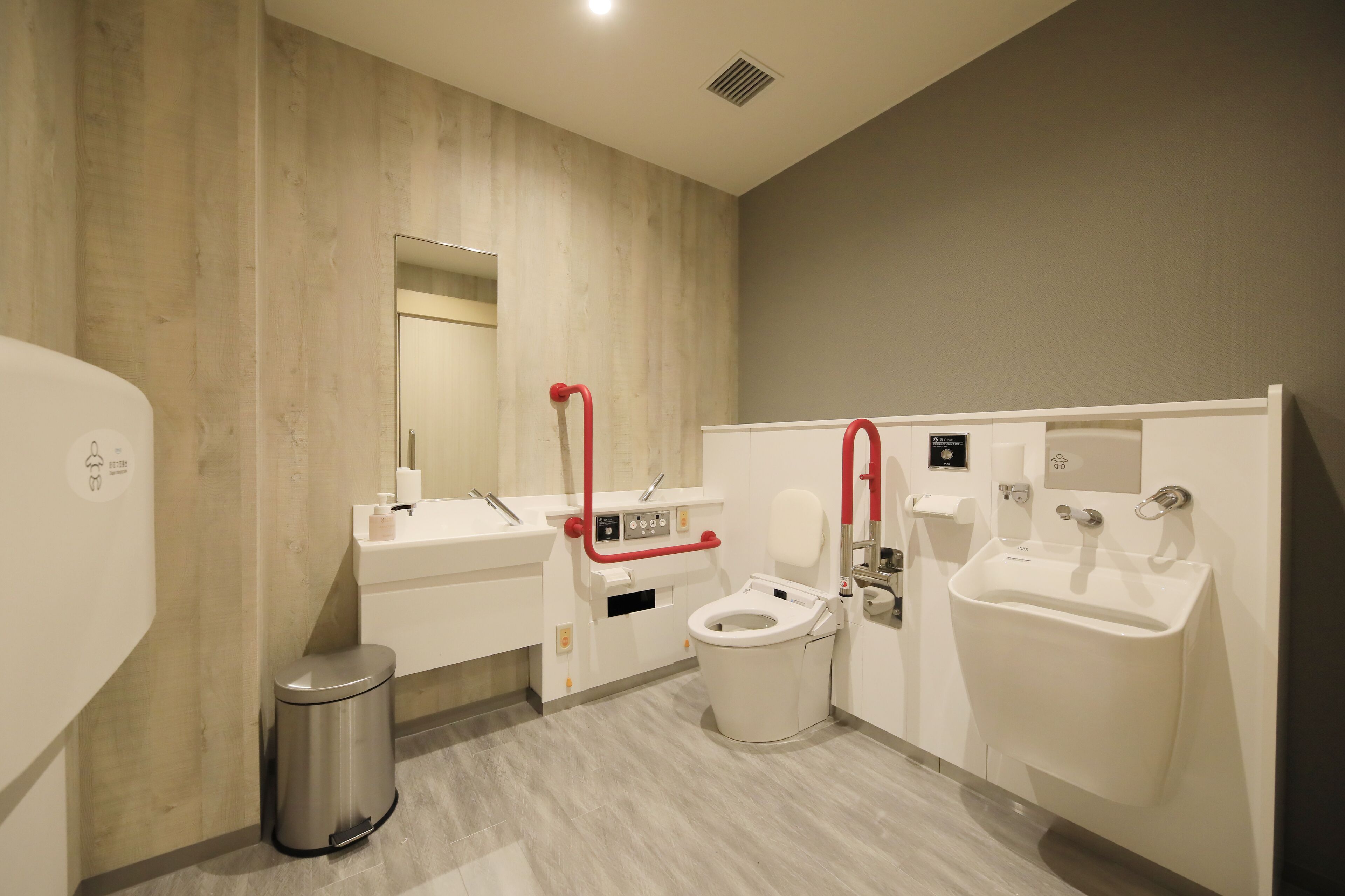 Een moderne badkamer met toilet, wastafel en douche-wc.