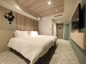 Habitación de hotel moderna con una cama grande, televisión de pantalla plana y un elemento decorativo en la pared.