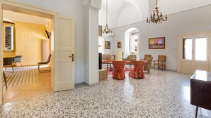 A spacious room with a high ceiling, a chandelier, and a patterned floor. - Antica Dimora Stasi by BarbarHouse (Acquarica del Capo)