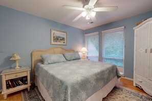 Relax in this cozy retreat with a comfortable bed, wicker headboard, and bedside table.