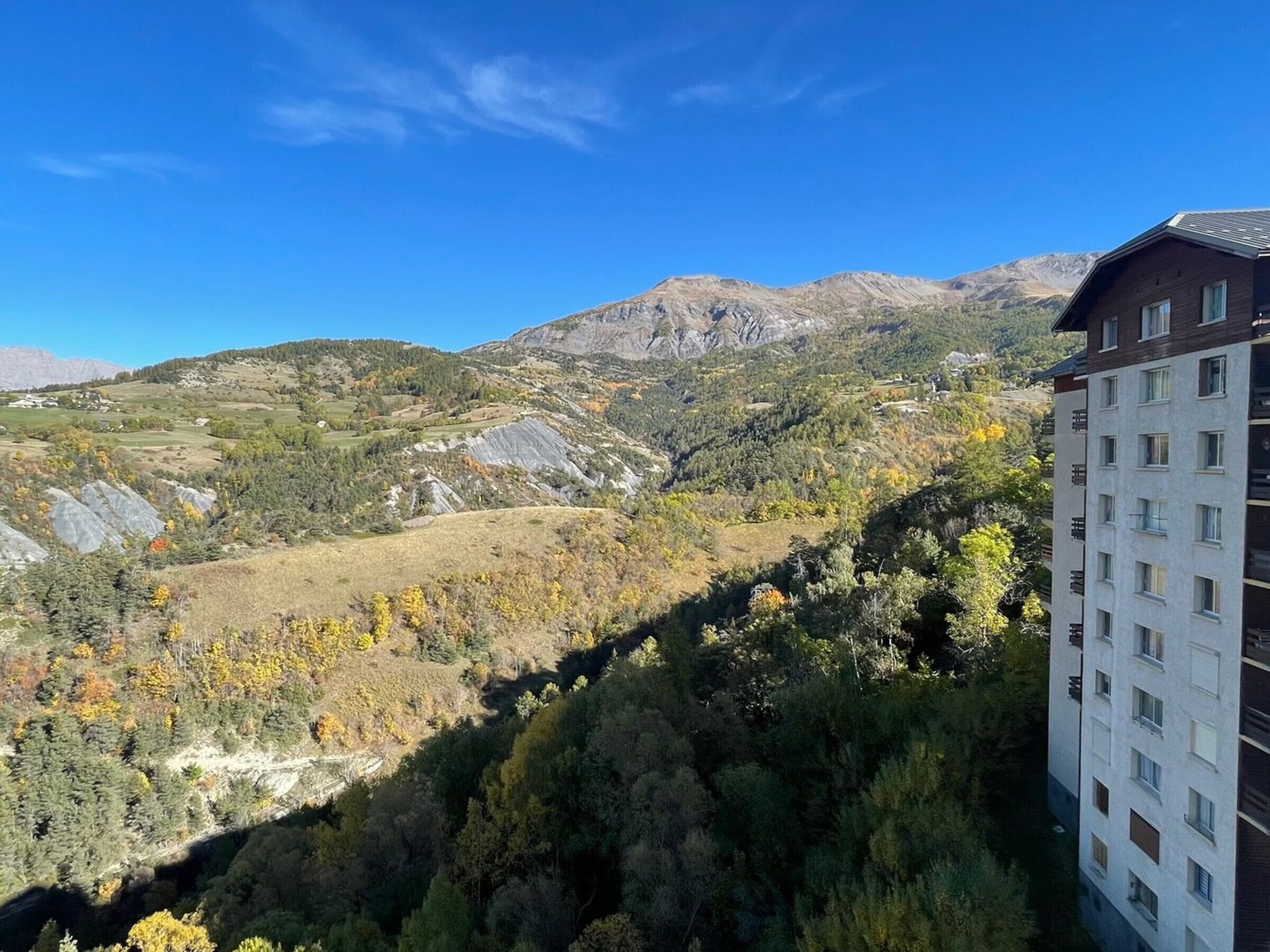 Un immeuble à plusieurs étages, doté d’une architecture moderne, situé dans une région montagneuse et offrant une vue sur le paysage environnant.