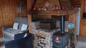 Ein gemütliches Blockhaus-Interieur mit Kamin, Sofa und Fernseher.
