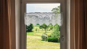 A window with a view of a grassy field and trees. - Charming Mountain View Cottage Near Gérardmer: Spacious, Cozy, Garden, Parking, Ideal for Hikes (Jussarupt)