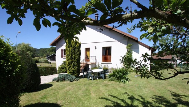 A white house with a red roof, a small garden, and a table with chairs outside. - Charming Mountain View Cottage Near Gérardmer: Spacious, Cozy, Garden, Parking, Ideal for Hikes (Jussarupt)