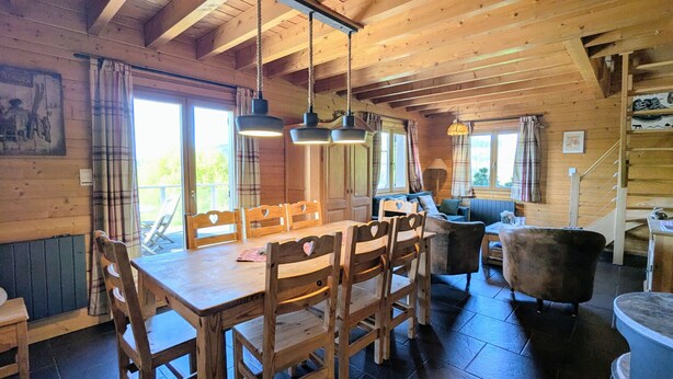 A wooden interior with a dining table, chairs, a sofa, and a staircase. - Comfortable chalet with terrace and wood stove, pets allowed (Le Tholy)
