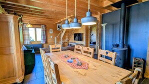 A wooden interior with a dining table, chairs, a staircase, and a fireplace. - Comfortable chalet with terrace and wood stove, pets allowed (Le Tholy)