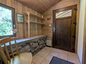 Un intérieur en bois avec un comptoir en pierre, une porte en bois et une chaise.