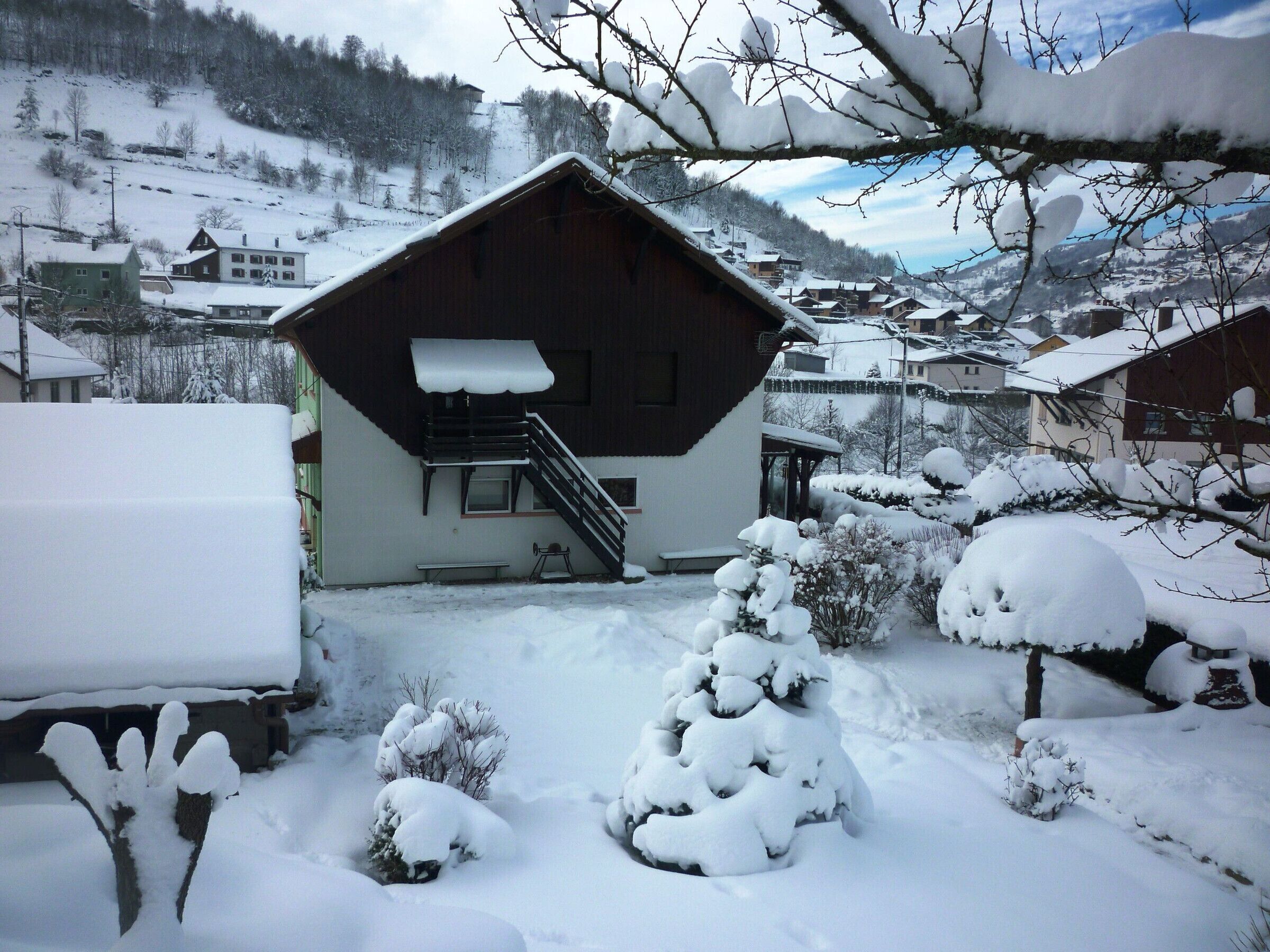 A snow-covered building with a staircase leading to a balcony.