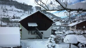 A snow-covered building with a staircase leading to a balcony.