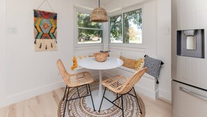 A kitchen with a round table, wicker chairs, a hanging light, and a refrigerator. - Remodeled, Private Pool & Hot Tub, Gas BBQ, Xbox, Ping Pong, Foosball, Fully-equipped Kitchen (Round Rock)