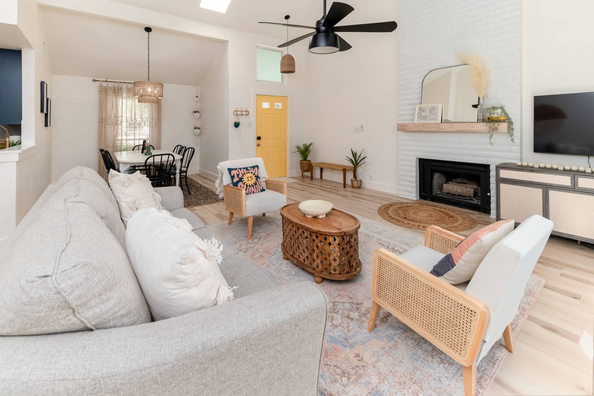 A spacious living room with a sofa, chairs, a coffee table, and a fireplace.