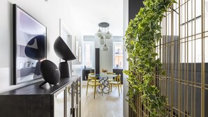 Una cocina moderna con comedor, que presenta una encimera negra, una mesa redonda y una lámpara colgante.