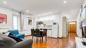 Um apartamento moderno com sala de estar, área de refeições, cozinha e corredor que leva a um quarto.