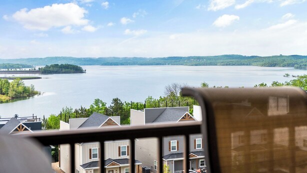 En vy över en sjö med hus i förgrunden och kullar i bakgrunden.