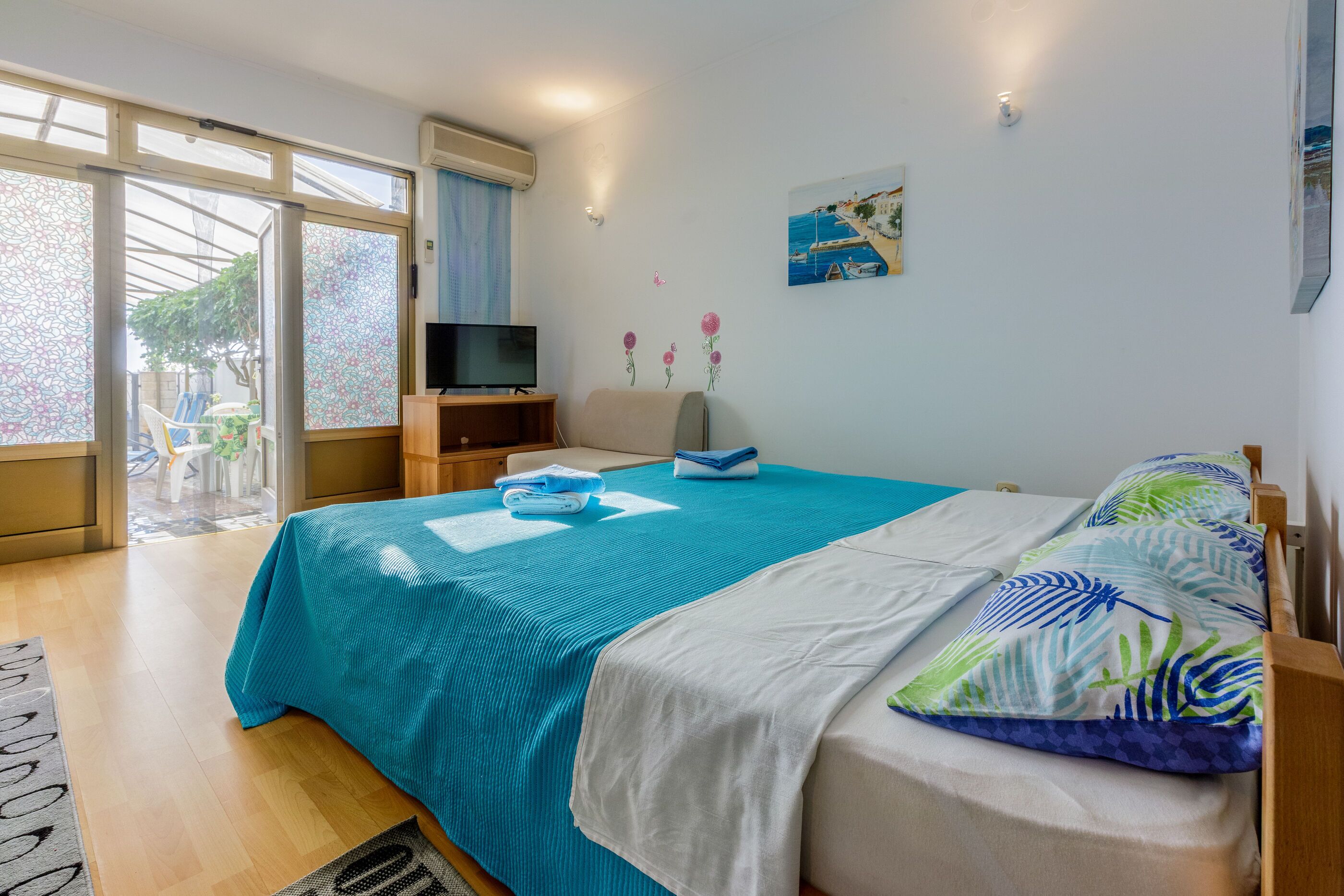 Een slaapkamer met een bed, een televisie en uitzicht op het omliggende landschap.