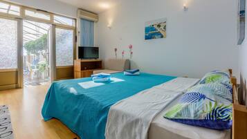 Een slaapkamer met een bed, een televisie en uitzicht op het omliggende landschap.