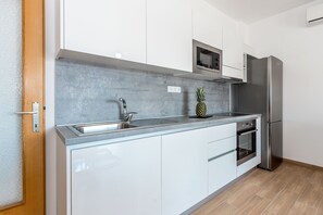 Cocina privada | Frigorífico, placa de cocina, lavavajillas y máquina de café espresso