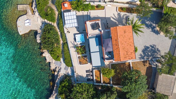 An aerial view of a coastal property with a swimming pool, sun loungers, and a tiled roof. - House Villa Fox (Kanica)