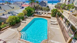 A swimming pool with a view of the ocean and palm trees. - Beachfront 1BR Condo | Pool | Hot Tub | Sleep 4 (Oceanside)