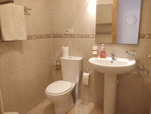 A bathroom with a toilet, sink, and mirror. - Bright Sea-front apartment: free WiFi, A/C,Fans,Playa Paraiso, Murcia,  La Manga (La Manga, Murcia)