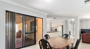 Enjoy meals in the dining area with a large table and four chairs, and step outside to the patio for a barbecue.