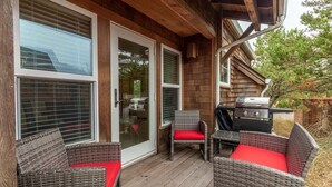 A covered porch with wicker furniture and a grill. - Seaside Paradise - lovely townhome, beach paths, dog OK (Pacific City)