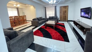 A modern living room with a sofa set, a coffee table, and a TV.