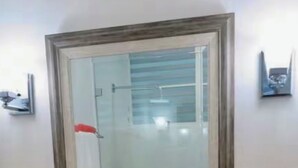 A bathroom with a wooden vanity, a mirror, a white sink, and a framed picture on the wall. - The Happy Place (San Juan)