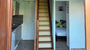 A staircase leading to a bedroom with a bed and a small window. - Rental with heated swimming pool 800m from the sea  (Brem-sur-Mer)