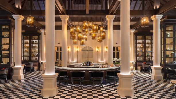 A bar area with a checkered floor, white columns, and hanging lanterns. - Hyatt Regency Phnom Penh (Phnom Penh)