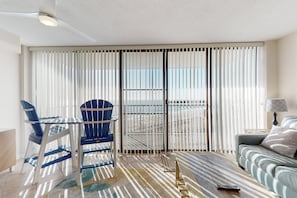 Relax in this ocean-view living room with a floor-to-ceiling window, sofa, and coffee table.