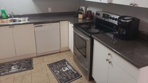 A kitchen with white cabinets, a microwave, a stove, and a dishwasher.