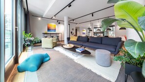 Una sala de estar moderna con sofá, mesa de centro y ventanas amplias.