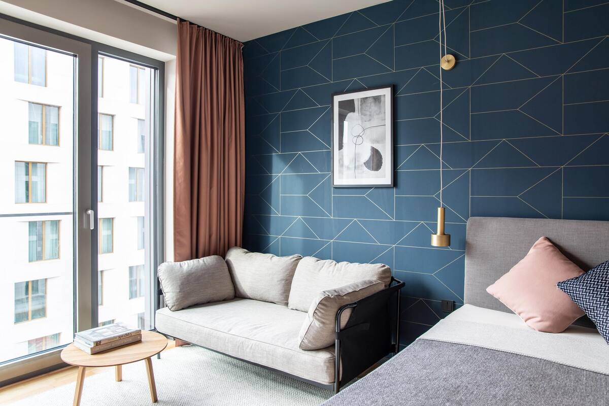Un salon moderne avec un canapé, une table basse et un lit avec des coussins.