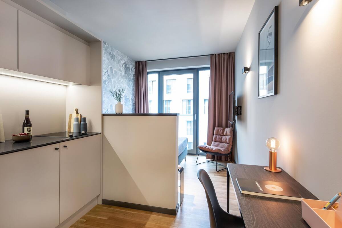 Une cuisine moderne avec un coin repas, une vue sur la ville et un espace salon confortable.