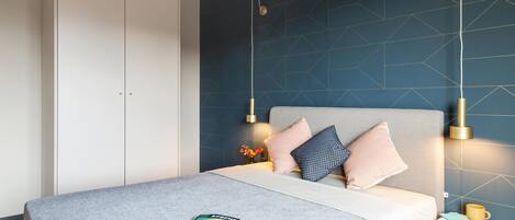 Une chambre à coucher moderne avec un lit, une table de chevet et une armoire.