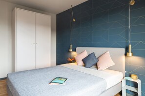 Une chambre à coucher moderne avec un lit, une table de chevet et une armoire.