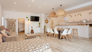 Un salon moderne comprenant un canapé, une table basse et un coin repas avec des chaises et une table.